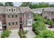 Attractive brick townhome showcasing dormer windows, shutters, and well-maintained landscaping at 565 Rose Garden Ln, Alpharetta, GA 30009