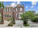 Beautiful brick townhome with attached garage, mature trees and manicured landscaping at 565 Rose Garden Ln, Alpharetta, GA 30009