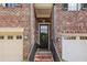 Charming front entrance with a black front door, brick steps, and a black metal handrail at 565 Rose Garden Ln, Alpharetta, GA 30009