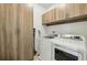 Laundry room with modern appliances and built-in cabinetry providing ample storage space for cleaning supplies and essentials at 565 Rose Garden Ln, Alpharetta, GA 30009