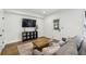 Comfortable living room with hardwood floors, a stylish sofa, a wooden coffee table, and a media center at 565 Rose Garden Ln, Alpharetta, GA 30009