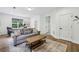 Bright living room with hardwood floors, gray sofa, natural light, and wooden coffee table at 565 Rose Garden Ln, Alpharetta, GA 30009