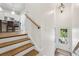 A staircase featuring wood treads, white risers, and an open view to a gourmet kitchen and living area at 565 Rose Garden Ln, Alpharetta, GA 30009