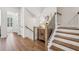 Hallway with hardwood floors and staircase with wood and iron railings, showcasing design at 565 Rose Garden Ln, Alpharetta, GA 30009