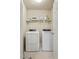 Laundry room with washer, dryer, overhead shelf, and neutral walls at 1110 Cureton Dr, Austell, GA 30106