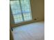 Cozy bedroom featuring a large window offering natural light, and neutral carpet at 1481 Yates Cv, Lawrenceville, GA 30043