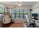 Inviting sun room with large windows, a comfortable wicker chair, and a desk area at 215 Summit North Ne Dr, Atlanta, GA 30324