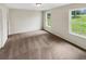 Sunlit bedroom with neutral walls, carpet, and large windows showcasing outdoor views at 690 Horsley Mill Rd, Carrollton, GA 30116