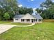 Charming home featuring a well-manicured front yard, metal roof, and inviting front porch at 690 Horsley Mill Rd, Carrollton, GA 30116