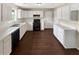 Spacious kitchen featuring white cabinets, hardwood floors, and modern black appliances at 690 Horsley Mill Rd, Carrollton, GA 30116
