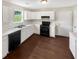Bright kitchen featuring hardwood floors, black appliances, and white cabinets at 690 Horsley Mill Rd, Carrollton, GA 30116