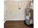 Utility room features a water heater, wooden flooring, and wire shelving at 690 Horsley Mill Rd, Carrollton, GA 30116