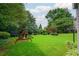 Spacious, well-maintained backyard with lush greenery, playground set, and trampoline at 1409 Echo Mill Dr, Powder Springs, GA 30127