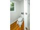 Bright bathroom featuring a toilet, window, and wood floors at 1409 Echo Mill Dr, Powder Springs, GA 30127
