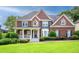 Beautiful two-story brick home featuring a manicured lawn, inviting porch and blue shutters at 1409 Echo Mill Dr, Powder Springs, GA 30127
