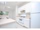Bright, all-white kitchen with modern appliances, white cabinets, countertops and sleek marble floors at 2594 Laurel Nw Cir, Atlanta, GA 30311