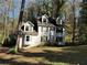 Two-story house with dormer windows surrounded by mature trees and foliage at 4232 Marjorie Rd, Snellville, GA 30039