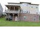 Rear exterior showcasing a deck, walkout basement, brick foundation, and backyard at 150 Canal St, Hampton, GA 30228