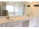 Bathroom featuring double sinks with white cabinetry, large mirror and a view of the soaking tub and shower at 150 Canal St, Hampton, GA 30228