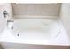 Close up of the large white soaking tub with tile surround at 150 Canal St, Hampton, GA 30228