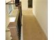 Carpeted hallway with oak railings and black spindles leads to more rooms at 150 Canal St, Hampton, GA 30228