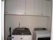 Laundry room featuring washer and dryer with white storage cabinets above at 150 Canal St, Hampton, GA 30228