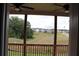 View from screened porch showcasing a grassy backyard, neighborhood, and wooded area beyond at 150 Canal St, Hampton, GA 30228