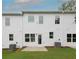 Exterior backyard view featuring a lawn, patio, and white townhouse at 1577 Aiden Way # 39, Conyers, GA 30013