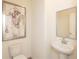 Half bathroom with a pedestal sink, toilet, framed mirror and contemporary artwork at 1577 Aiden Way # 39, Conyers, GA 30013