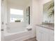 Bathroom with a soaking tub, granite counters, modern fixtures, and large window with natural light at 1577 Aiden Way # 39, Conyers, GA 30013