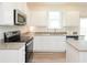 Well-lit kitchen with stainless steel appliances, white cabinetry, granite countertops, and a center island at 1577 Aiden Way # 39, Conyers, GA 30013