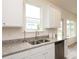 Kitchen sink with stainless steel faucet, granite countertops, white cabinets, and a stainless steel dishwasher at 1577 Aiden Way # 39, Conyers, GA 30013