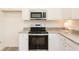 Close-up of the kitchen with stainless steel oven and microwave surrounded by white cabinets and granite countertops at 1577 Aiden Way # 39, Conyers, GA 30013