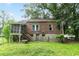 Exterior of a brick house with a screened-in porch and stairs to a stone-clad basement at 1699 Emerald Sw Ave, Atlanta, GA 30310