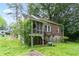 Back exterior view featuring a brick home, screened porch, and lush green yard with trees at 1699 Emerald Sw Ave, Atlanta, GA 30310