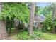 Brick home with white trim is partially obscured by lush trees and greenery at 1699 Emerald Sw Ave, Atlanta, GA 30310
