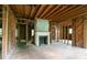 Spacious living room under renovation featuring a fireplace, exposed framing, and wood flooring at 1699 Emerald Sw Ave, Atlanta, GA 30310