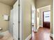 Hallway with hardwood floors leading to a bathroom and a dark wood door at the end at 384 16Th Nw St # 1, Atlanta, GA 30363