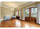 Elegant room with hardwood floors, chandelier and access to the outdoor balcony through wood doors at 384 16Th Nw St # 1, Atlanta, GA 30363