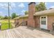 Spacious wooden deck offering backyard views, accessible by a back door with brick chimney at 7928 S Giles Rd, Douglasville, GA 30135