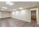 Spacious finished basement with wood-look floors, neutral walls, drop ceiling, and access to stairs at 7928 S Giles Rd, Douglasville, GA 30135