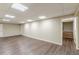 Spacious basement with wood floors, neutral paint, and access to stairs at 7928 S Giles Rd, Douglasville, GA 30135
