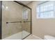 Bathroom featuring tiled shower with a glass door and a window for natural light at 7928 S Giles Rd, Douglasville, GA 30135