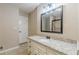 Bathroom featuring granite countertop vanity, decorative mirror, and tiled floor at 7928 S Giles Rd, Douglasville, GA 30135