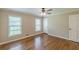 Spacious bedroom featuring hardwood floors, two windows, a ceiling fan, and neutral-toned walls at 7928 S Giles Rd, Douglasville, GA 30135