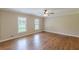 Large bedroom featuring hardwood floors and natural light from two windows at 7928 S Giles Rd, Douglasville, GA 30135