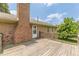 Spacious wooden deck and brick exterior featuring a brick chimney and white door at 7928 S Giles Rd, Douglasville, GA 30135