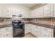 Charming kitchen featuring white cabinetry, granite countertops, and modern appliances at 7928 S Giles Rd, Douglasville, GA 30135