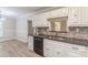 Bright kitchen features white cabinets, black countertops and backsplash, and stainless steel appliances at 7928 S Giles Rd, Douglasville, GA 30135