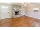 Inviting living room featuring a stone fireplace, hardwood floors, ceiling fan, and a white front door at 7928 S Giles Rd, Douglasville, GA 30135